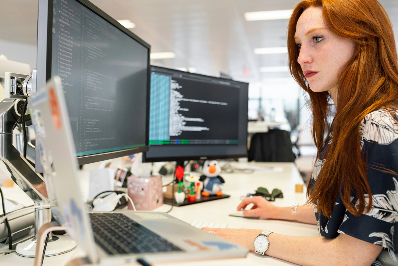 Image of a woman in front of desktops in an office - Destination Certification